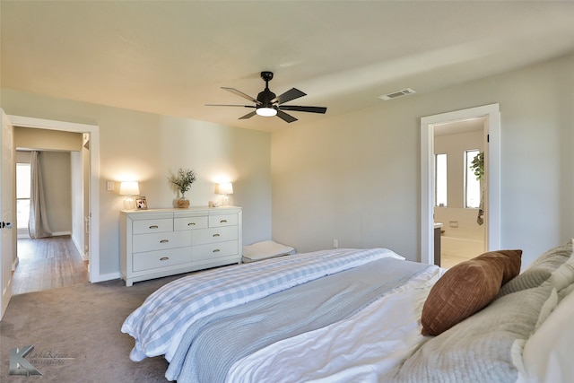 bedroom with ceiling fan, ensuite bathroom, and carpet floors