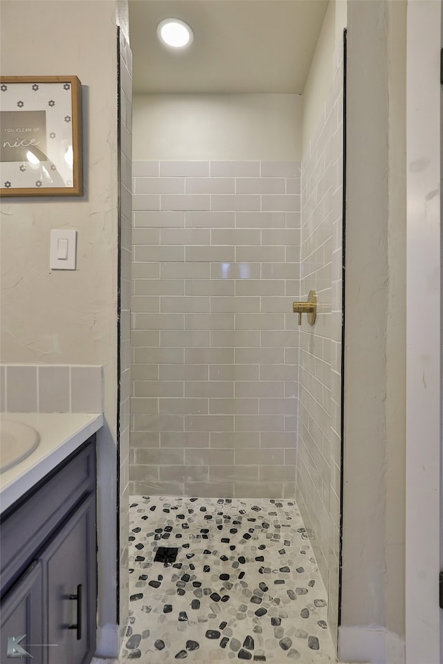 bathroom with vanity and a tile shower