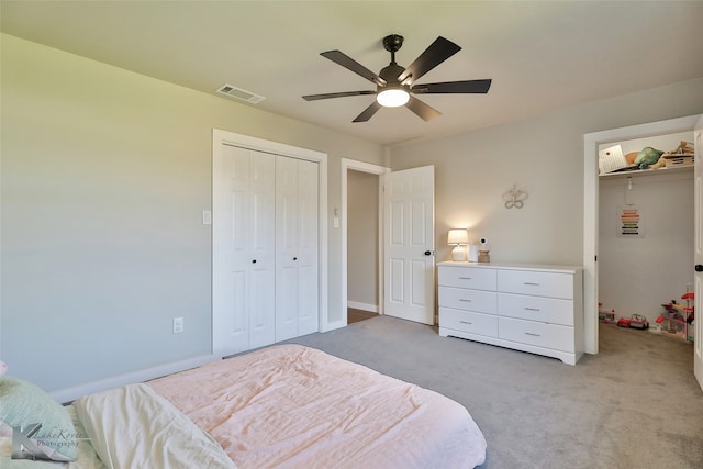 bedroom with a closet, ceiling fan, and light carpet