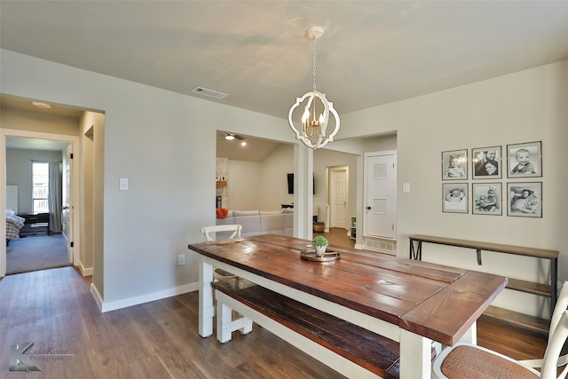 dining space featuring dark hardwood / wood-style flooring and a notable chandelier