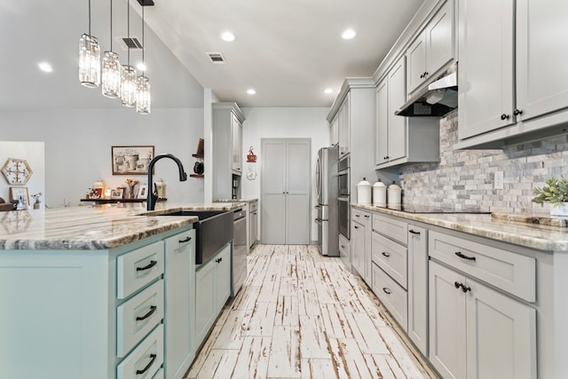 kitchen featuring backsplash, light stone counters, sink, black electric cooktop, and pendant lighting