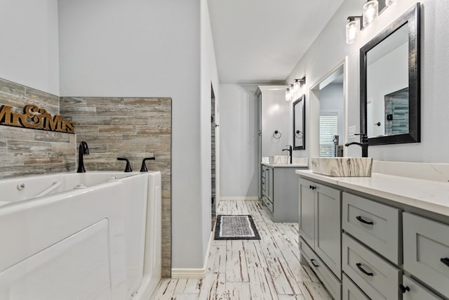 bathroom with vanity, a bath, and tile walls