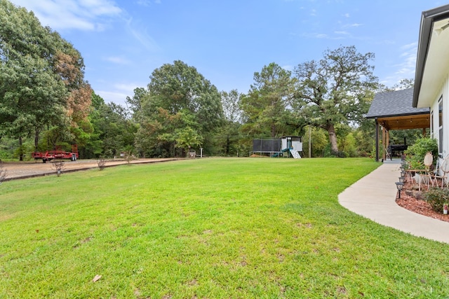 view of yard featuring a playground, a patio, and a trampoline