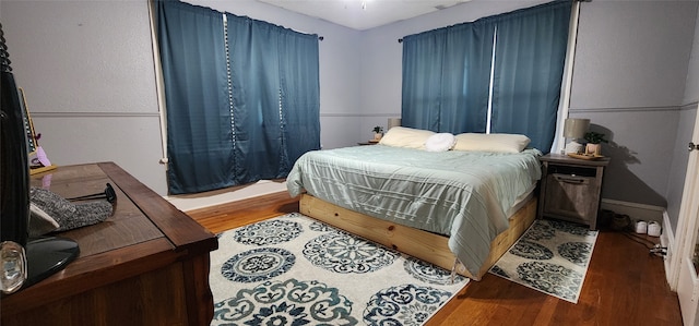 bedroom with dark hardwood / wood-style flooring