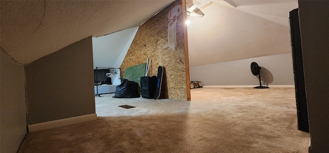 additional living space featuring light colored carpet and vaulted ceiling