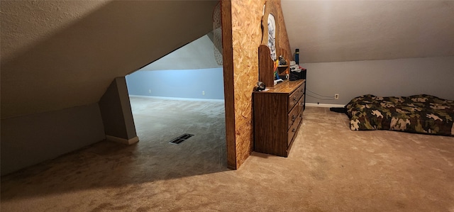 interior space featuring a textured ceiling, light colored carpet, and vaulted ceiling