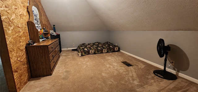 carpeted bedroom featuring lofted ceiling and a textured ceiling