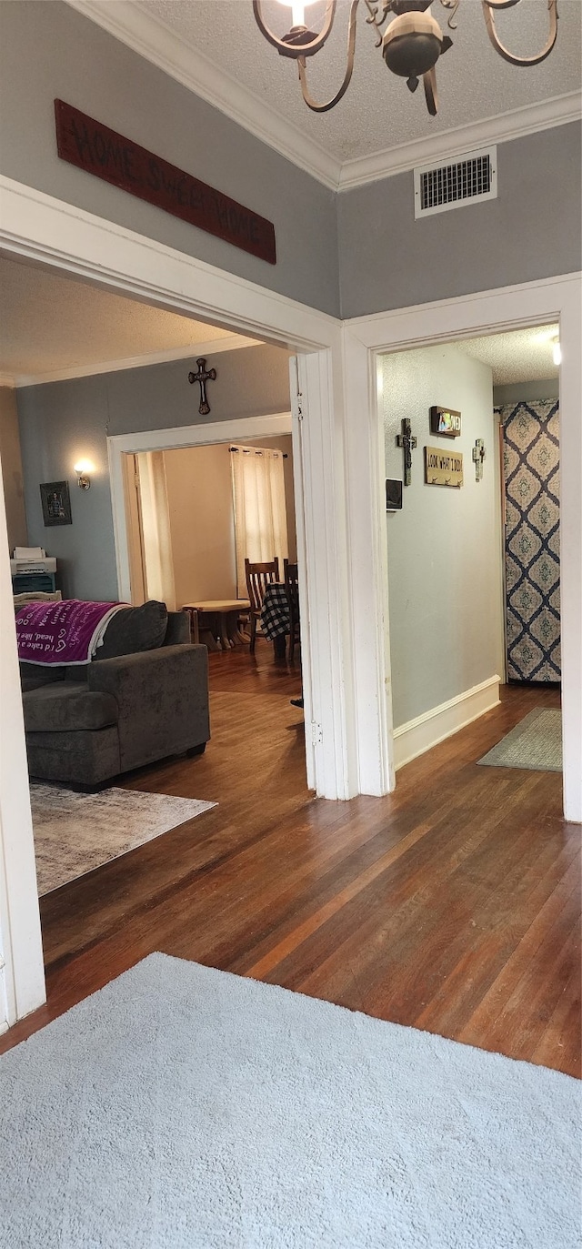 living room featuring ornamental molding, a textured ceiling, and hardwood / wood-style flooring