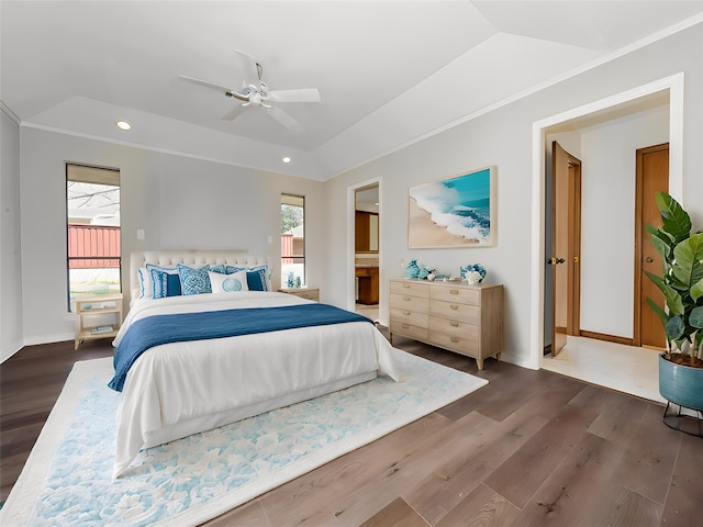 bedroom featuring ensuite bath, dark hardwood / wood-style flooring, a tray ceiling, and ceiling fan