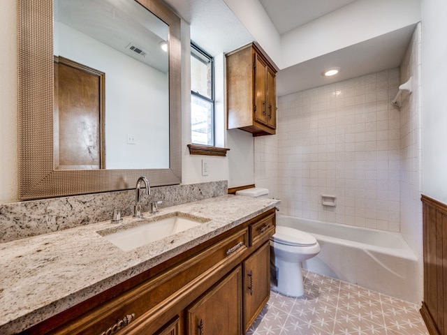 full bathroom featuring tile patterned flooring, tiled shower / bath, toilet, and vanity