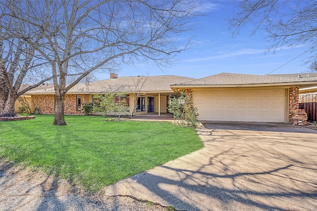 ranch-style house featuring a garage and a front lawn