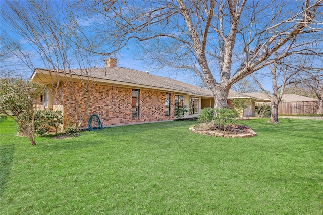 rear view of house featuring a yard