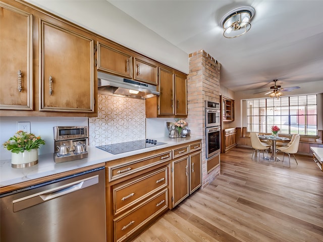 kitchen featuring ceiling fan, stainless steel appliances, light hardwood / wood-style floors, and tasteful backsplash