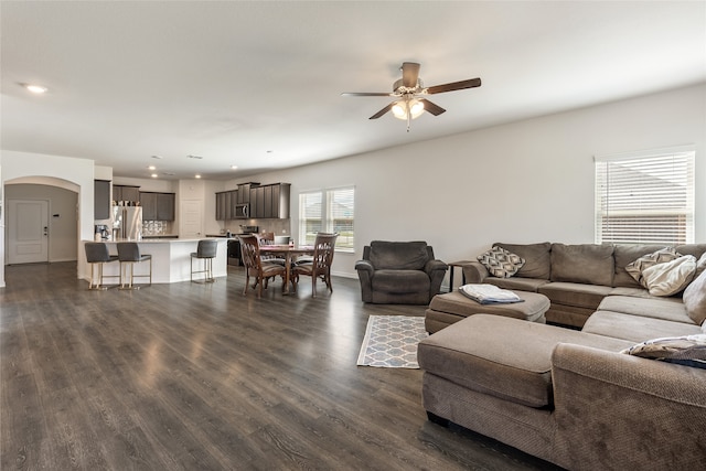 living room featuring ceiling fan and dark hardwood / wood-style floors