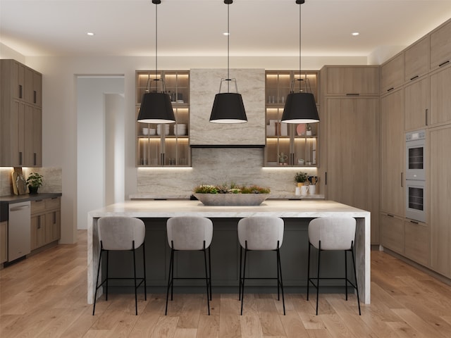 kitchen featuring stainless steel dishwasher, a kitchen breakfast bar, and light wood-type flooring