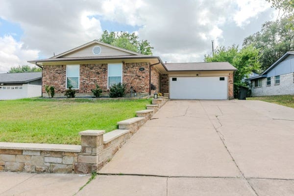 ranch-style home with a front yard and a garage