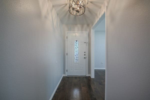 entryway with an inviting chandelier and dark hardwood / wood-style floors