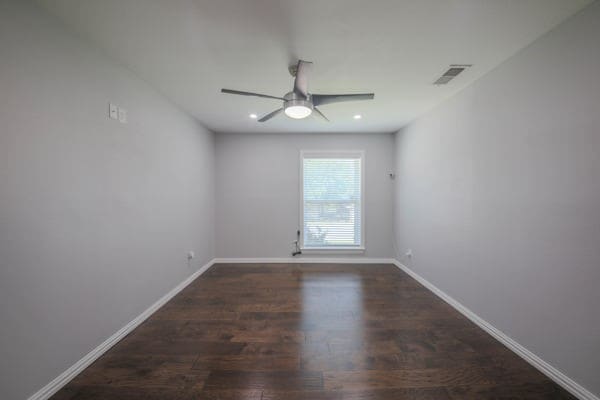 unfurnished room featuring dark hardwood / wood-style floors and ceiling fan