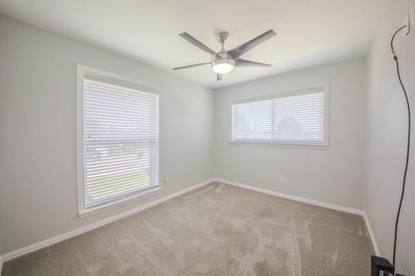 unfurnished room with ceiling fan and light colored carpet