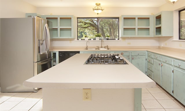 kitchen with light tile patterned floors, sink, appliances with stainless steel finishes, and a center island