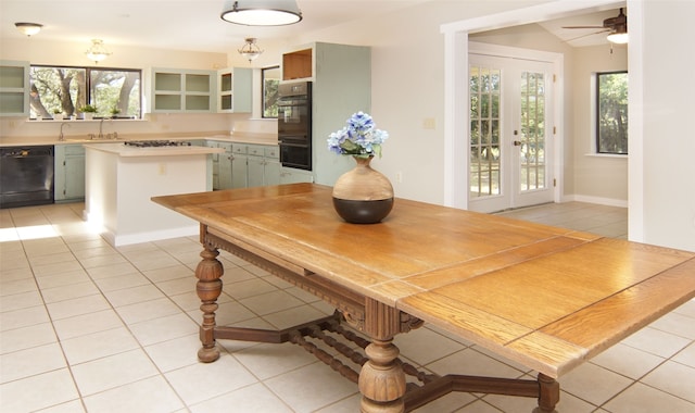 dining room with ceiling fan, light tile patterned flooring, lofted ceiling, and sink