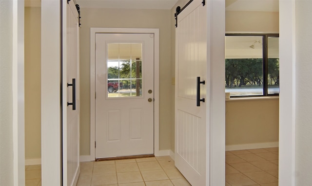 doorway to outside with light tile patterned floors and a barn door