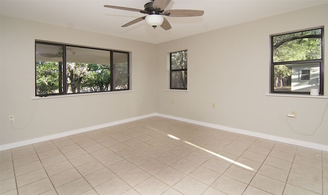 tiled spare room featuring ceiling fan and plenty of natural light