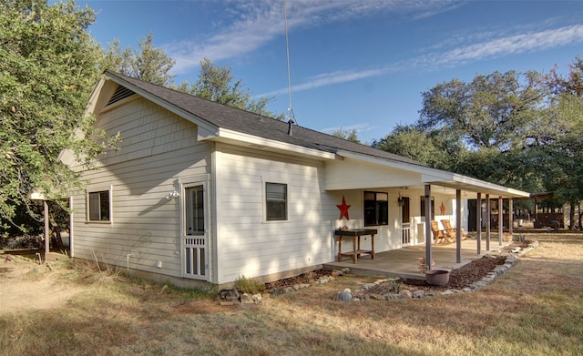 rear view of house with a yard and a patio