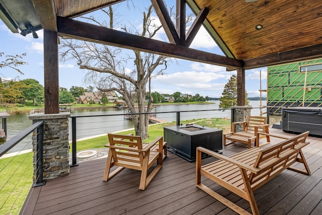 wooden terrace with a water view and an outdoor fire pit