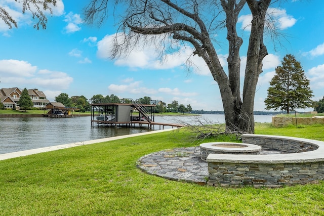 view of dock with a water view and a lawn