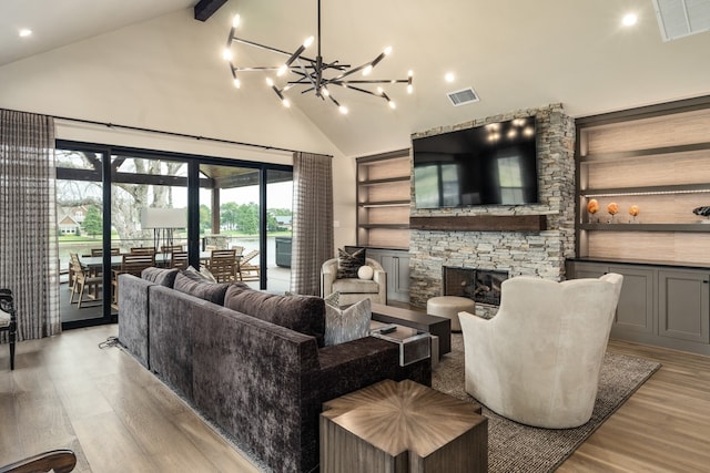 living room with a stone fireplace, beamed ceiling, high vaulted ceiling, a notable chandelier, and light wood-type flooring