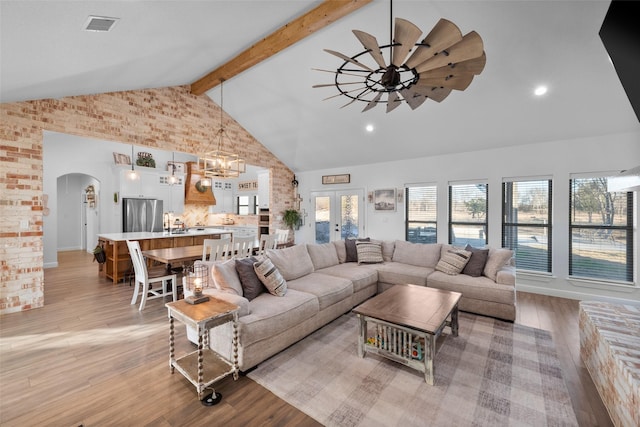 living room featuring ceiling fan, sink, beamed ceiling, light wood-type flooring, and french doors