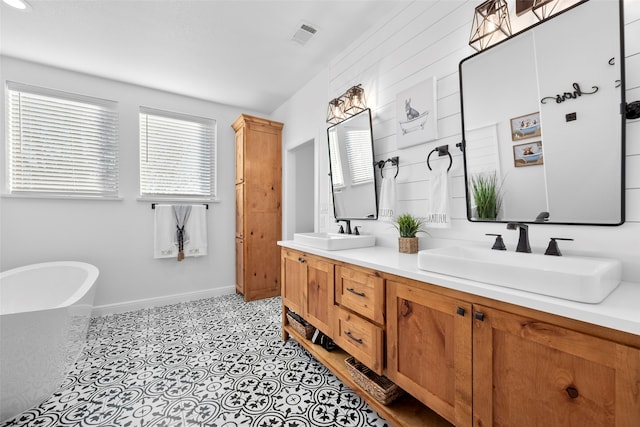 bathroom with tile patterned flooring, a bathtub, and vanity