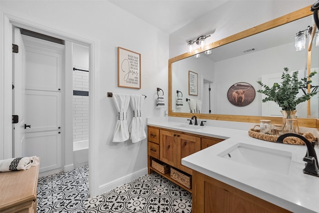 bathroom featuring tiled shower / bath combo, vanity, and tile patterned floors