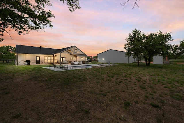 yard at dusk with a shed and a patio area