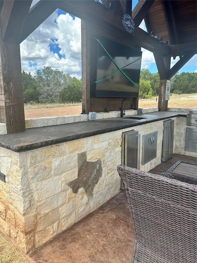 view of patio / terrace with an outdoor kitchen, a grill, and sink