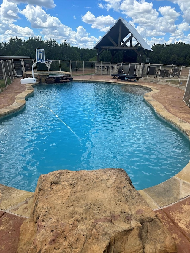 view of pool with an in ground hot tub and a patio