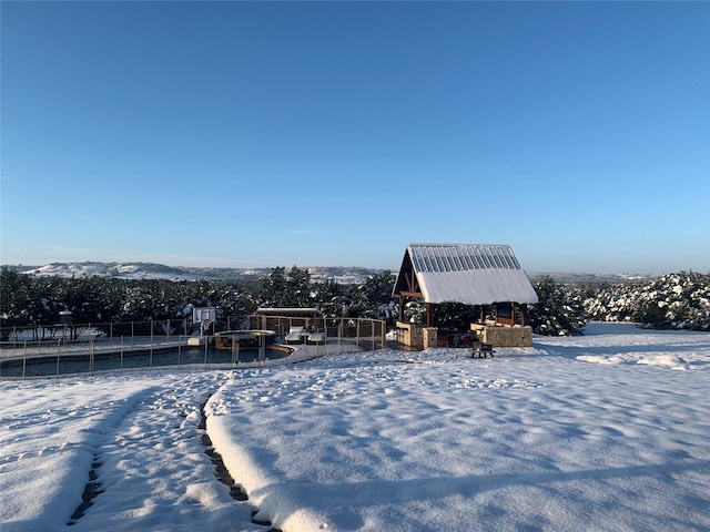 yard layered in snow featuring a mountain view and a trampoline