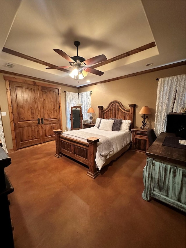 bedroom featuring a raised ceiling, ceiling fan, carpet floors, and ornamental molding