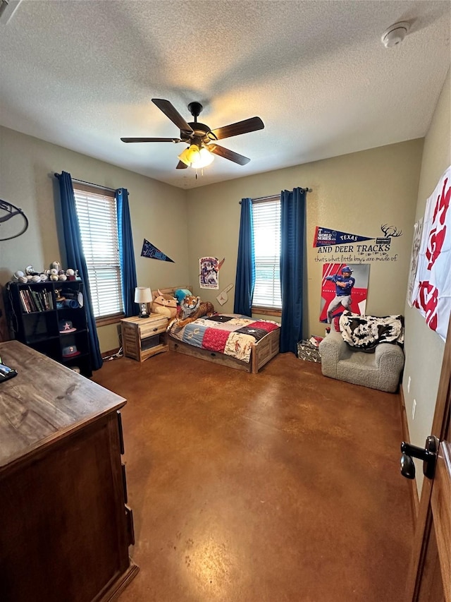 bedroom featuring ceiling fan, concrete flooring, and a textured ceiling