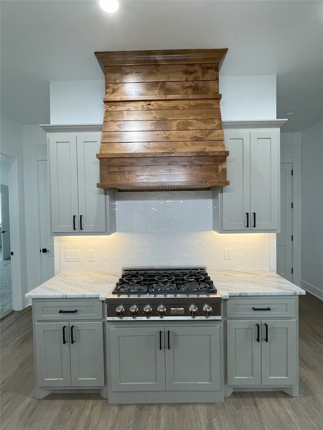 1428 Dixie Estates Way, Whitesboro, TX 76273 - kitchen featuring stovetop, custom exhaust hood, light wood-style floors, and tasteful backsplash