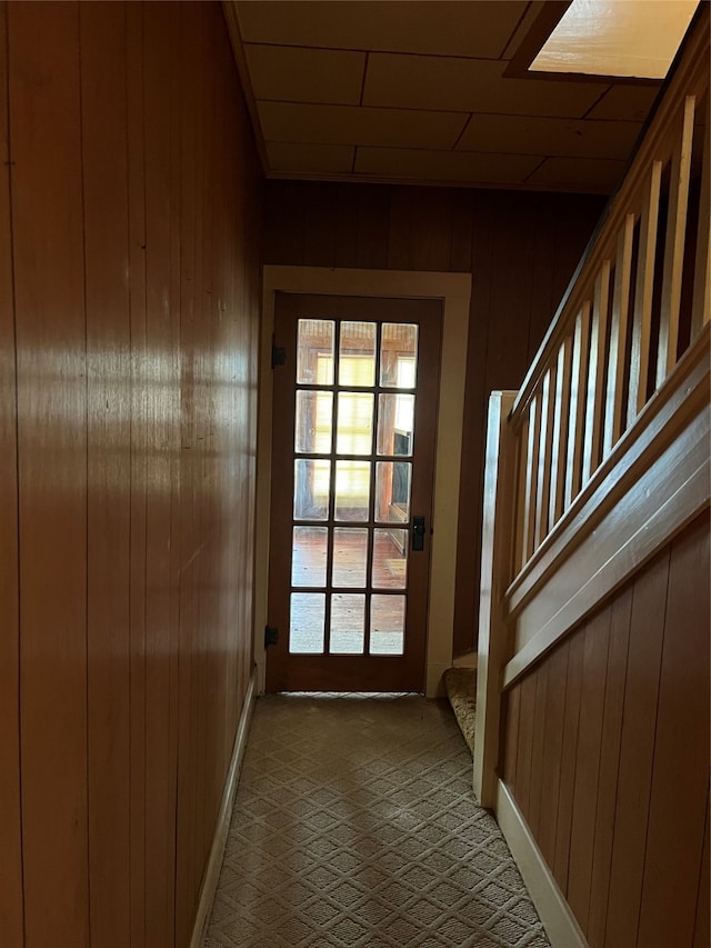 doorway to outside with wooden walls