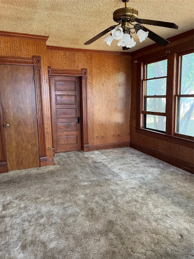 spare room with a textured ceiling, ceiling fan, and carpet