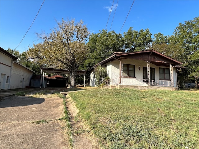 rear view of property featuring a porch and a yard