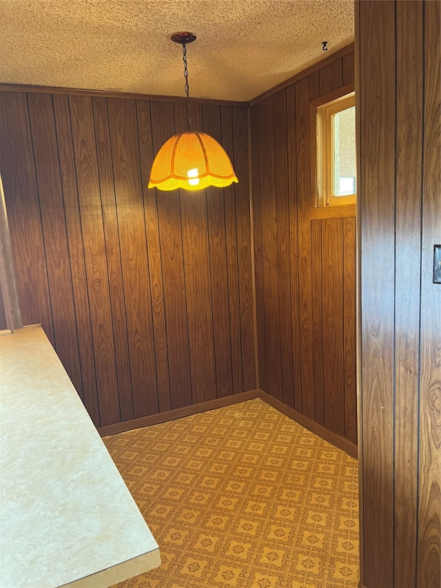 empty room featuring a textured ceiling and wooden walls