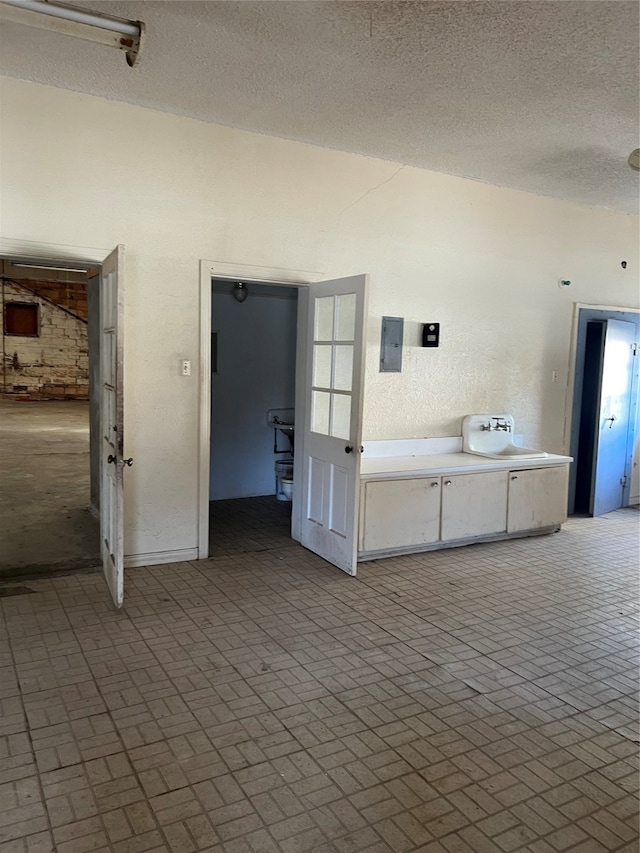 empty room featuring a textured ceiling and electric panel