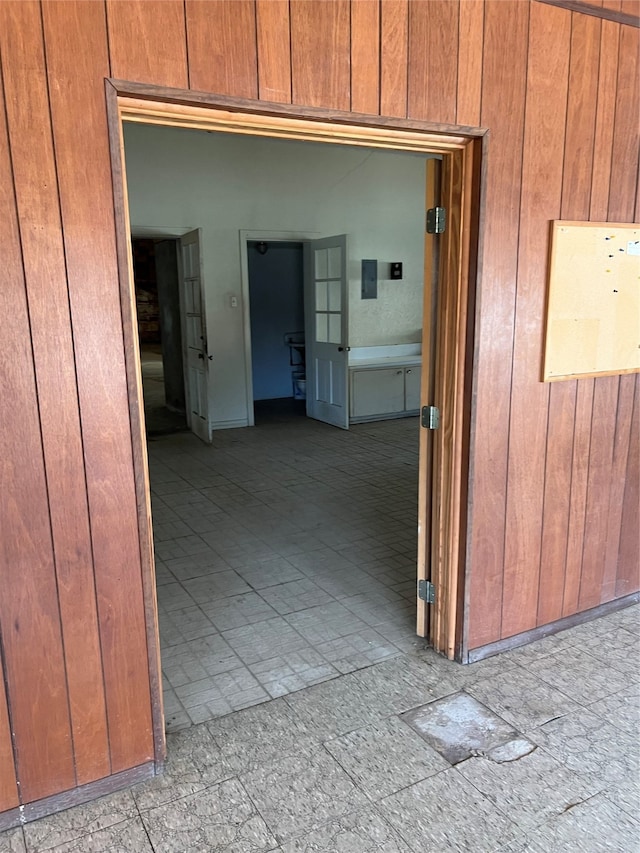 hallway featuring wood walls