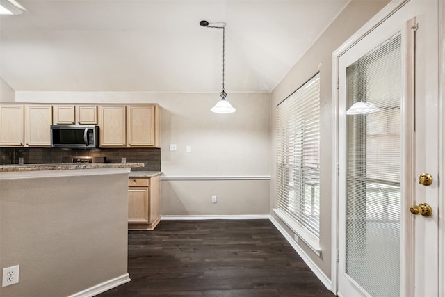 kitchen with light brown cabinets, decorative backsplash, hanging light fixtures, and vaulted ceiling