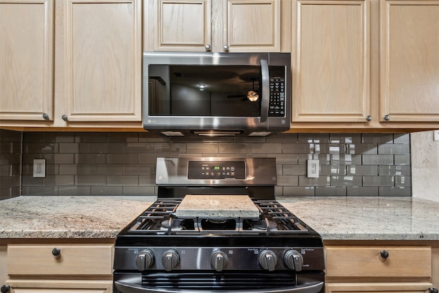 kitchen featuring light brown cabinets, stainless steel appliances, and backsplash