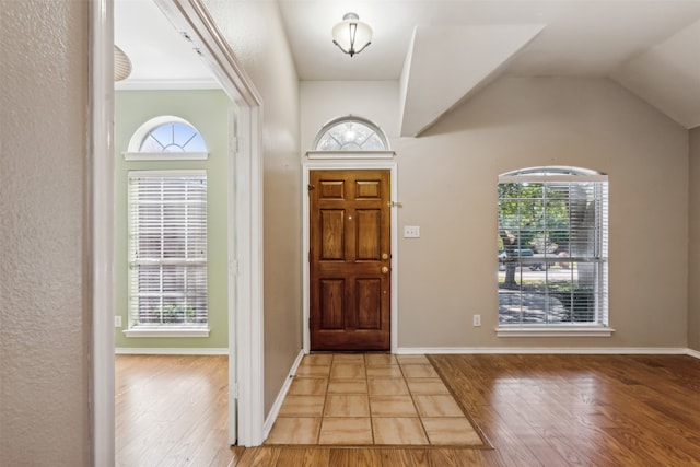 foyer entrance with lofted ceiling, hardwood / wood-style floors, and a healthy amount of sunlight